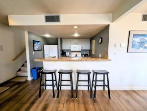 a kitchen with four bar stools in a room at Quicksilver 1607 by SummitCove Lodging in Keystone