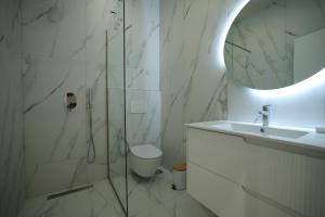 a bathroom with a shower and a toilet and a sink at Rooms Kruja City in Krujë +51 photos