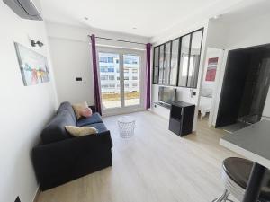 a living room with a couch and a television at Strasbourg Centre et Parlement in Strasbourg