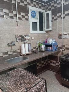 a kitchen counter with a sink and a window at sidi bashr el tram street ali abi bash in Banī Ghālib