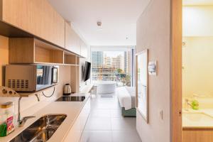 a kitchen with a sink and a large window at Porto Horizonte Apartamentos in Santa Marta