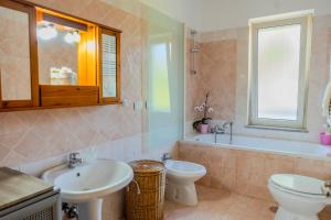 a bathroom with two sinks and a tub and a toilet at Casa Carmen in Stazione di Paestum