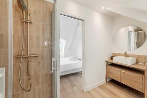 Un baño con ducha, lavabo y espejo. en Bord de l'eau 6 - Sea view - 3 people, en Cancale