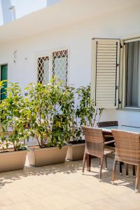 a patio with a table and chairs and potted plants at Casa Carmen in Stazione di Paestum +19 photos