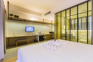 Un dormitorio con una cama blanca y un televisor. en Snoozz Hotel Krabi, en Krabi 47 fotos más