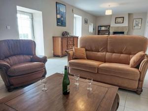 a living room with a couch and wine glasses on a table at Holiday Home Le Brieux by Interhome in Quimper