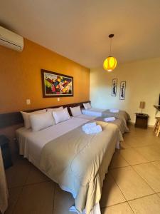 a hotel room with three beds in a room at Villa Zen Pirenópolis Conforto e Bem-Estar in Pirenópolis +73 photos