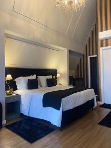 a bedroom with a large bed and a chandelier at Hotel Villa Verde - by Easy Hotéis in São Bento do Sul