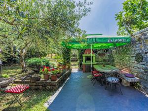 a patio with a table and chairs and a green umbrella at Apartment Lorena by Interhome in Buje +16 photos