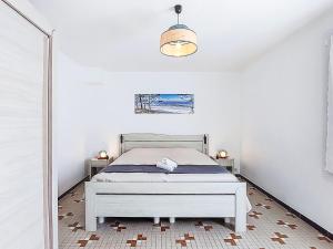 Un dormitorio blanco con una cama y un espejo. en Holiday Home La Coti by Interhome, en Saint-Pierre-dʼOléron