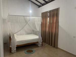 un dormitorio con una cama con dosel en Three Brothers Villa, en Mirissa