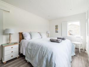 a white bedroom with a large bed and a window at Holiday Home Cobble Cottage by Interhome in Lerryn +26 photos