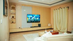 a living room with a tv on the wall at NJIRO 4BDR FAMILY HOME NEAR RESTURANTs AFCON EXERCISE Field in Arusha