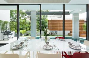 ein weißes Esszimmer mit einem weißen Tisch und Stühlen in der Unterkunft Modern Luxury Poolhaus with Lift in Klong Toi