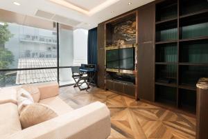 ein Wohnzimmer mit Sofa und Fernseher in der Unterkunft Modern Luxury Poolhaus with Lift in Klong Toi