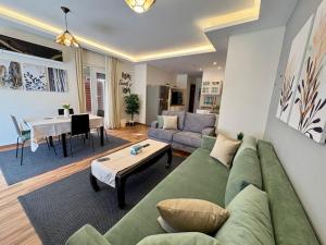 a living room with a green couch and a table at Top rated 1bedroom in Karma compound Sheikh Zayed - only families & single travelers in Sheikh Zayed +45 photos