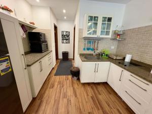 a kitchen with white cabinets and a wooden floor at Top rated 1bedroom in Karma compound Sheikh Zayed - only families & single travelers in Sheikh Zayed