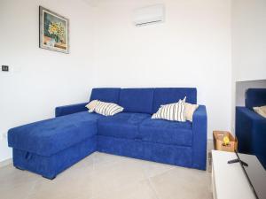 a blue couch sitting in a living room at Holiday Home Sova by Interhome in Nečujam