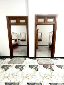 two mirrors in a room with a bed at Domestic Villa in Arugam Bay +24 photos