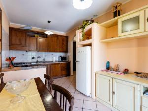 a kitchen with a table and a white refrigerator at Holiday Home Ca'de Pauline by Interhome in Gazzelli