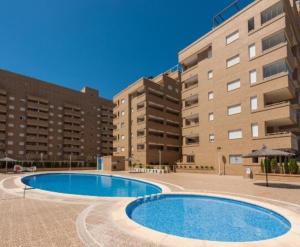 an empty swimming pool in front of a building at JARDINES DEL MAR II Vitamina D todo el año entre playa y montaña in El Borseral