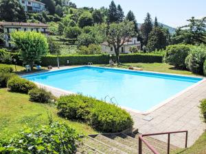 a large swimming pool in a yard with bushes at Apartment Villa Castiglioni by Interhome in Luino