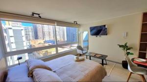 1 dormitorio grande con ventana grande y cama grande en Modernos departamentos, en Santiago