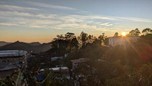 vista para o pôr-do-sol sobre uma cidade em Sousam Cottage em Kodaikānāl