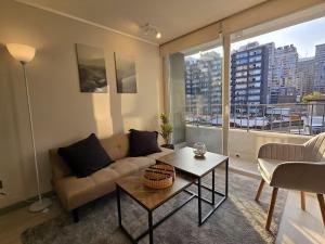 una sala de estar con un sofá y una mesa en Modernos departamentos, en Santiago
