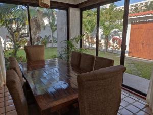 a dining room table and chairs with a table and windows at Cancún Villa Marina Blanca in Cedro