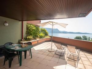 a patio with a table and chairs and an umbrella at Apartment Norby by Interhome in Ghiffa