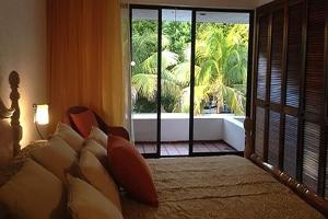 a bedroom with a large bed and a large window at Cancún Villa Marina Blanca in Cedro