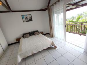 a bedroom with a bed and a balcony at Résidence Mélodie 65m2 - Meublée et toute équipée - Maison de vacances #1 in Le Tampon
