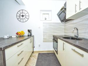 Una cocina con gabinetes blancos y un fregadero. en Holiday Home Villa Meri by Interhome, en Benkovac