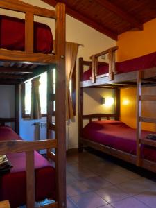 a room with three bunk beds in a house at Hostel El Mirador in El Bolsón