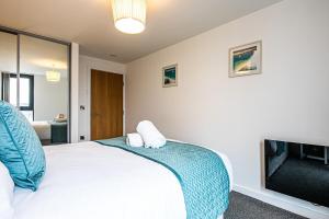 a bedroom with a white bed and a tv at iQuarter Apartment - City Centre - Free Secure Parking, Self-Check-In, Fast Wifi and Smart TV by Yoko Property in Sheffield
