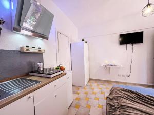 a kitchen with white cabinets and a white refrigerator at Apartment Mono 0-8-N Marineledda by Interhome in Golfo Aranci