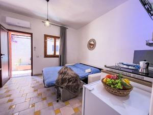 a room with a bed and a bowl of fruit on a counter at Apartment Mono 0-8-N Marineledda by Interhome in Golfo Aranci +26 photos