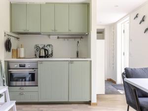 a kitchen with green cabinets and a stove at Holiday Home Särdals Lycke by Interhome in Steninge +20 photos