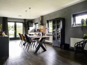 una cucina e una sala da pranzo con tavolo e sedie di Holiday Home Vosseberghuis Prestige & Outdoor Spa by Interhome a Vlagtwedde