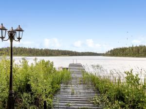 a wooden walkway over a lake with a street light at Holiday Home Jönsamåla by Interhome in Ryd
