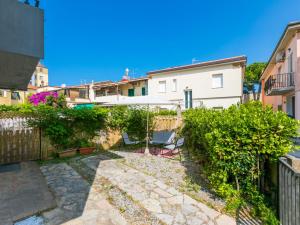une terrasse avec un parasol blanc et quelques buissons dans l'établissement Apartment Casa Rico by Interhome, à Cecina