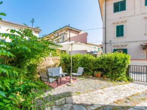 un patio avec deux chaises et un parasol dans l'établissement Apartment Casa Rico by Interhome, à Cecina 31 autres photos