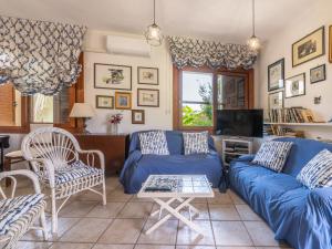 a living room with a blue couch and a tv at Villa Villa Al Mare by Interhome in Su Forti