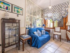 a living room with a blue couch and a chair at Villa Villa Al Mare by Interhome in Su Forti