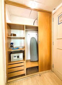 Un armario con un microondas y una tabla de surf dentro. en Apartamento com Estrutura de Hotel na Barra, en Río de Janeiro