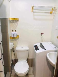 a small bathroom with a toilet and a sink at Sky Suites at Spring Residences Condotel near NAIA and SM Bicutan Mall in Manila