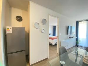 a living room with a refrigerator and a bedroom at Apart Total Centro Belmonte in Temuco