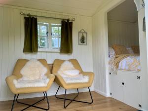 1 Schlafzimmer mit 2 Stühlen und 1 Bett in der Unterkunft Tower Farm Holidays in Llangollen