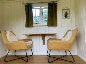 zwei Stühle und ein Tisch in einem Raum mit einem Fenster in der Unterkunft Tower Farm Holidays in Llangollen